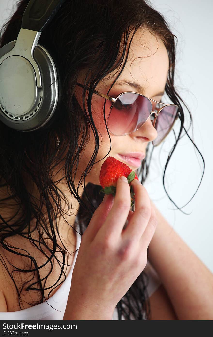 Happy woman dance in phones and eat strawberry. Happy woman dance in phones and eat strawberry