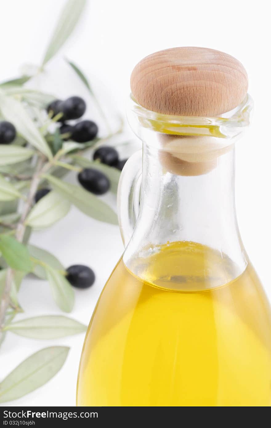 A bottle of virgin olive oil with a branch of olive tree