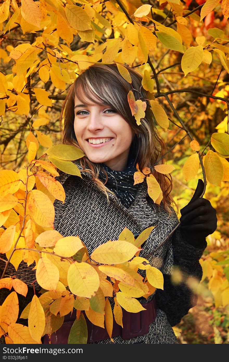 Beautiful Girl Among Yellow Autumn Leaves