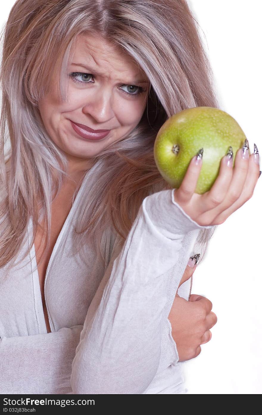 The lovely girl holds a green apple on a white background. The lovely girl holds a green apple on a white background