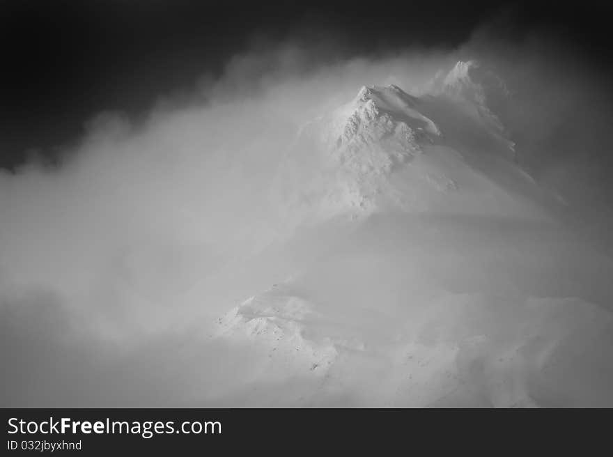 Clouds hovering around a snowy mountain peak, Mt. Hood