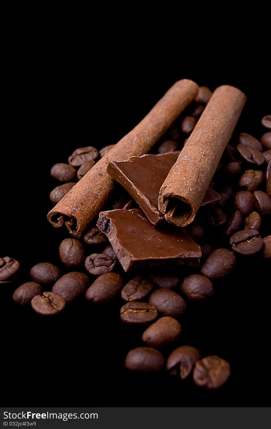 Cinnamon Sticks Over Coffee Beans And Chocolate