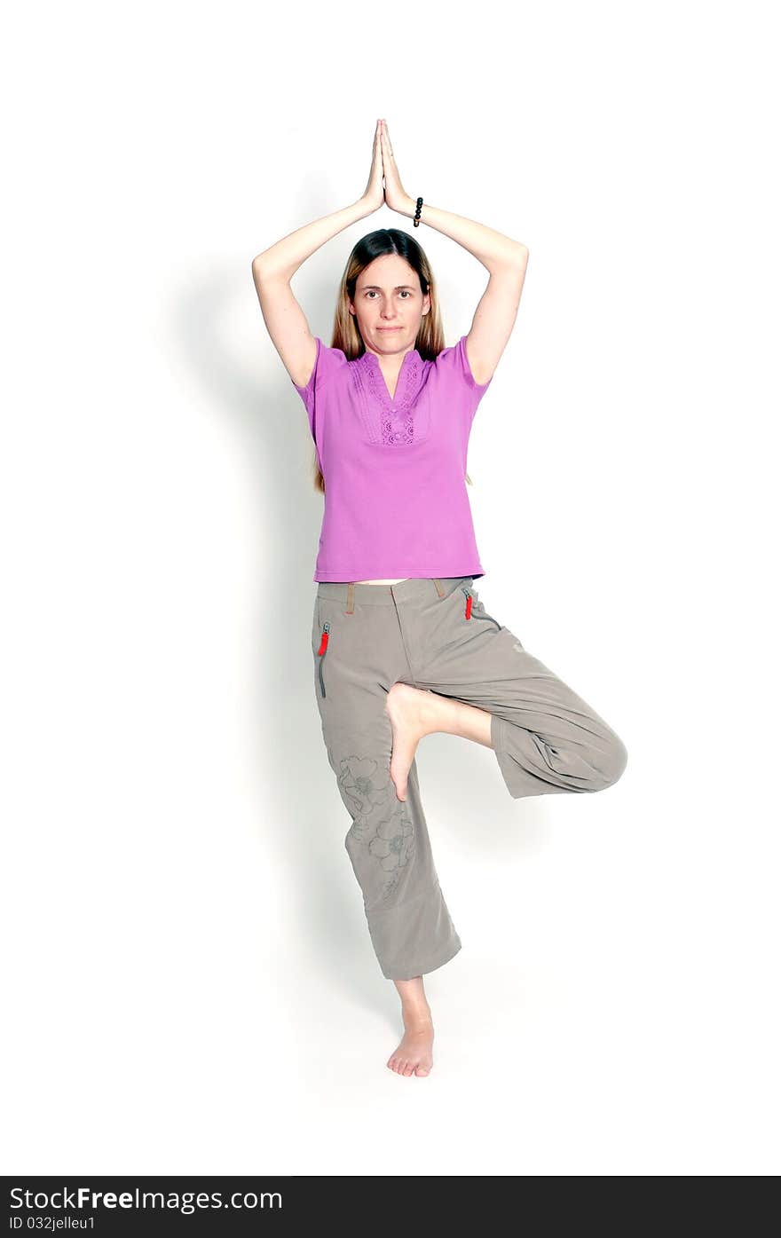 Young woman practicing yoga in the tree posture