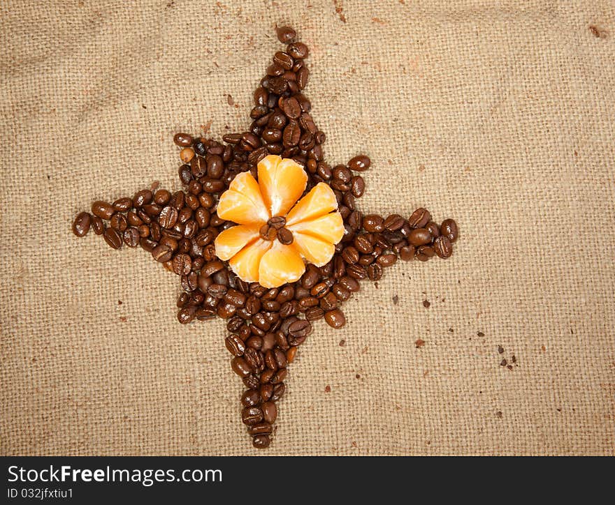 Fragrant fried coffee beans as a star with tangerine. Fragrant fried coffee beans as a star with tangerine