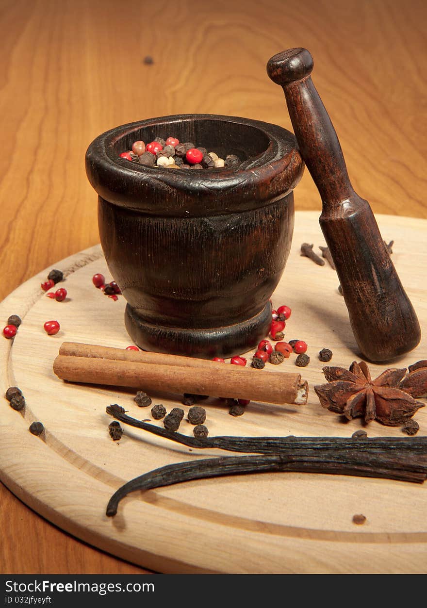 Mix of the spices on the wooden desk with wooden mortar