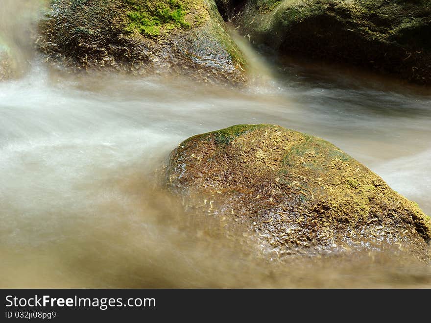 Wet stones lying in the fast stream. Wet stones lying in the fast stream