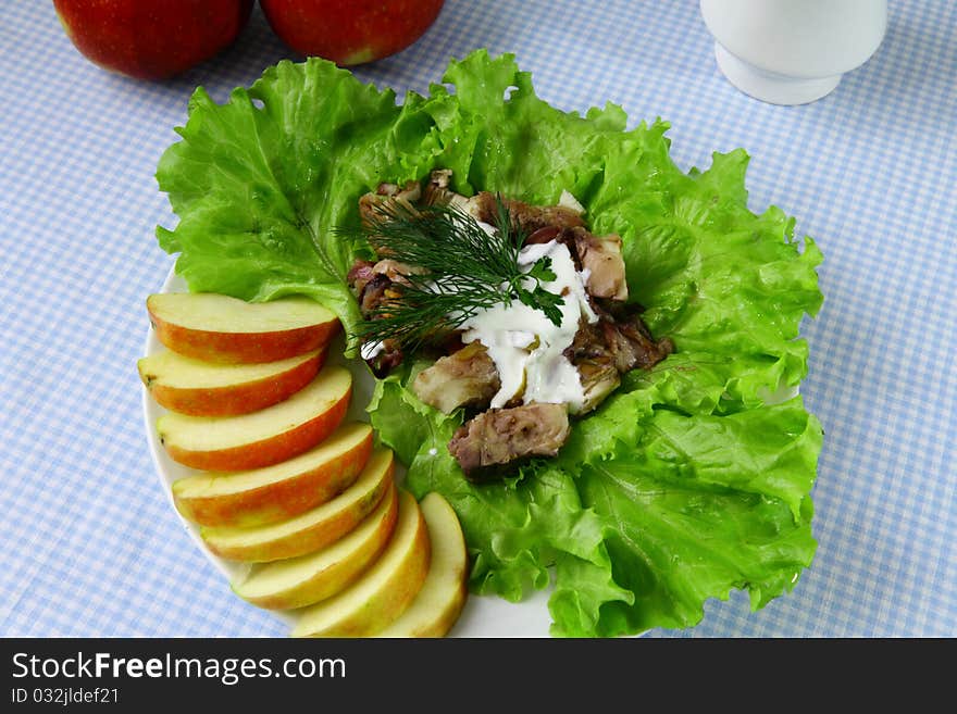 Fish with pieces of apple and lettuce on the plate. Fish with pieces of apple and lettuce on the plate