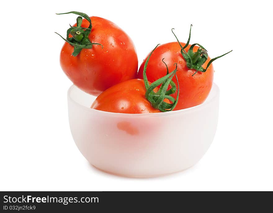 Three juicy tomatoes in the plate isolated on the white