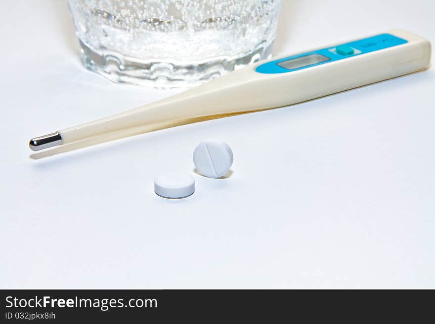 Thermometer with tablets of analgetic and a glass of water. Thermometer with tablets of analgetic and a glass of water