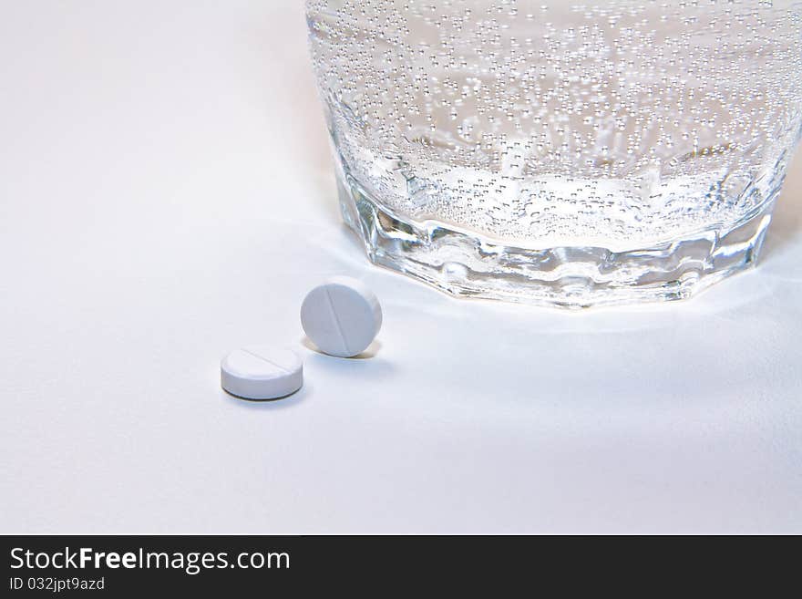 Two pills and a glass of water. Two pills and a glass of water