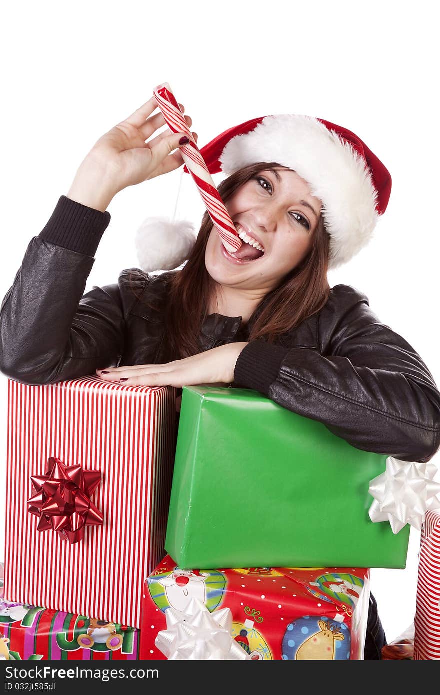 A woman is leaning on a stack of presents licking a peppermint stick. A woman is leaning on a stack of presents licking a peppermint stick.