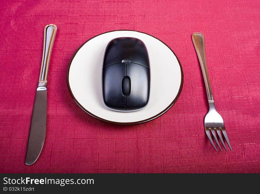 Concept: fork, plate with mouse and knife on a table. Concept: fork, plate with mouse and knife on a table