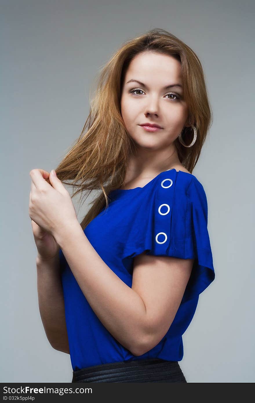 Beautiful woman in blue top with long brown hair - isolated on gray. Beautiful woman in blue top with long brown hair - isolated on gray