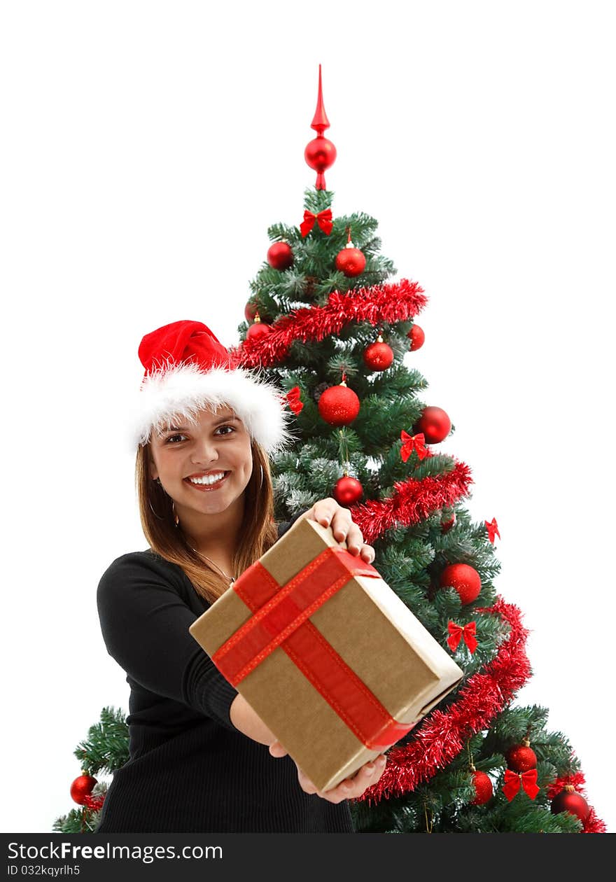 Pretty young woman giving a gift to us near the Christmas tree. Pretty young woman giving a gift to us near the Christmas tree