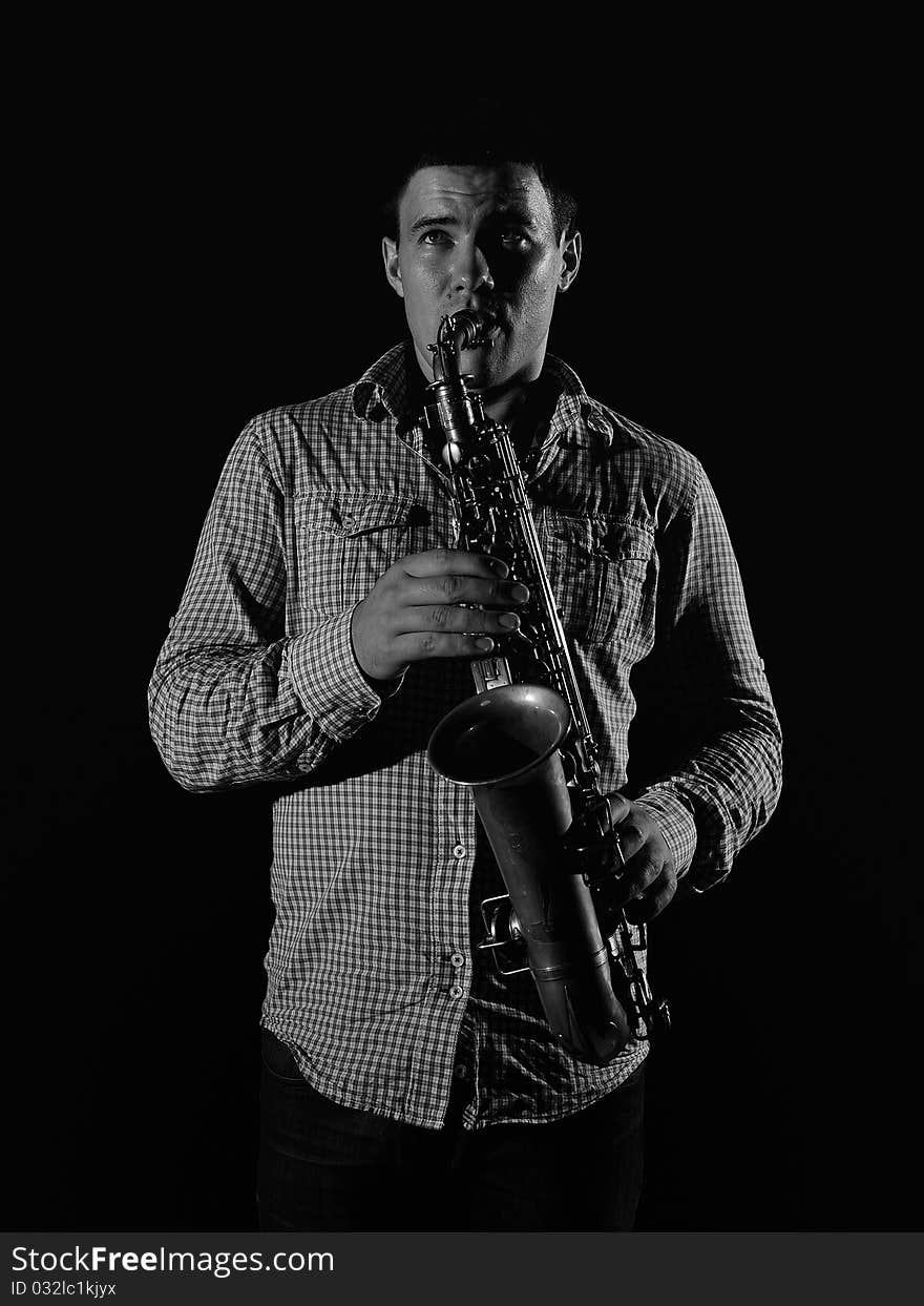 Young handsome man playing music on saxophone