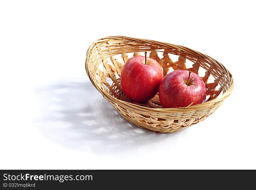 Red apples in the basket isolated on white background