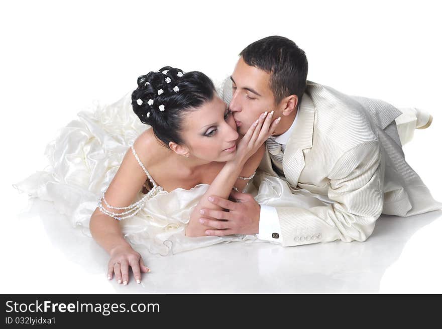 Isolated on white groom is kissing his bride wearing in wedding dress. Isolated on white groom is kissing his bride wearing in wedding dress