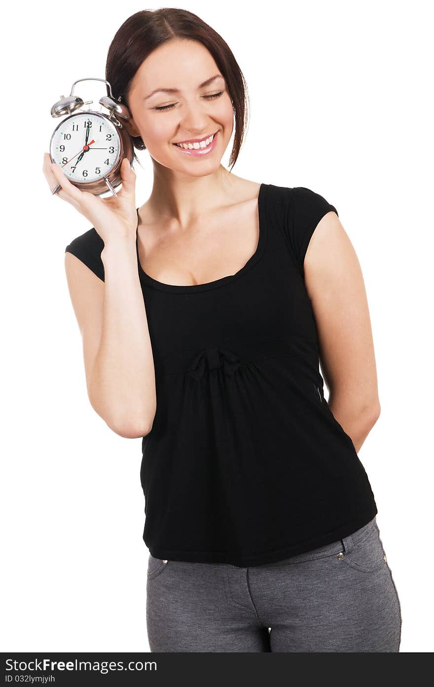 Cheerful young woman listening to the ticking of alarm clock. Cheerful young woman listening to the ticking of alarm clock