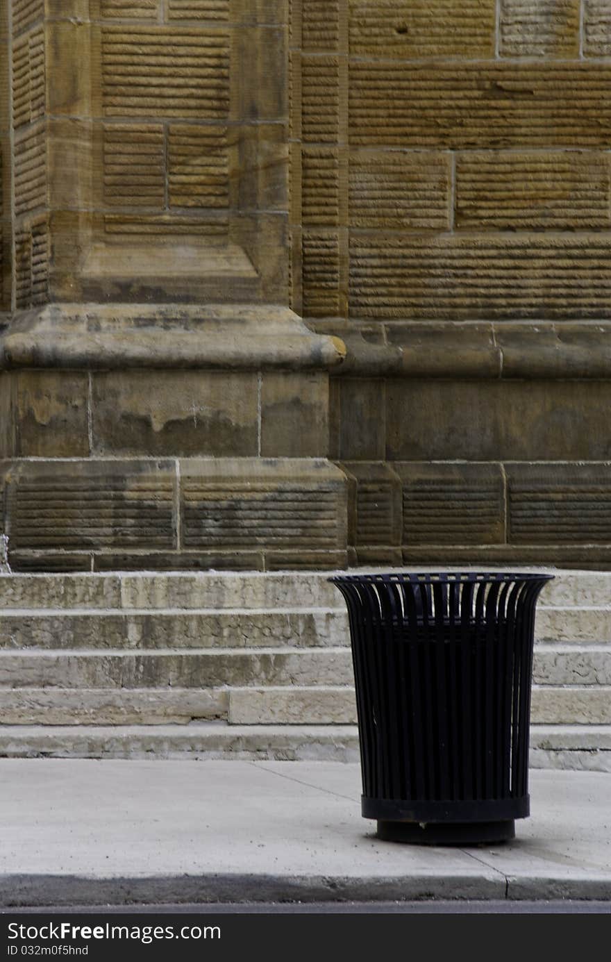 A curb side receptacle in front of a brick building. A curb side receptacle in front of a brick building.