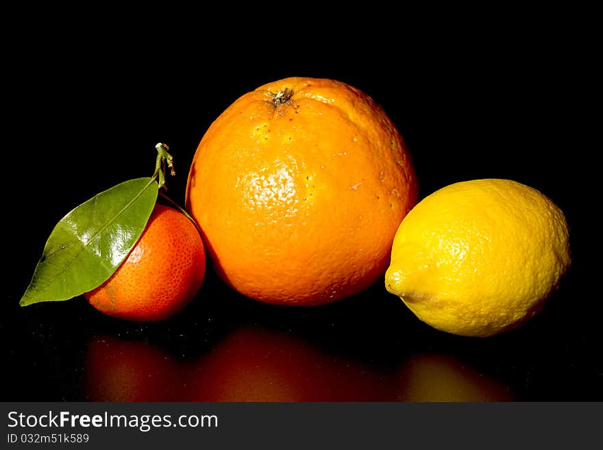 Clementine orange and lemon on black background. Clementine orange and lemon on black background