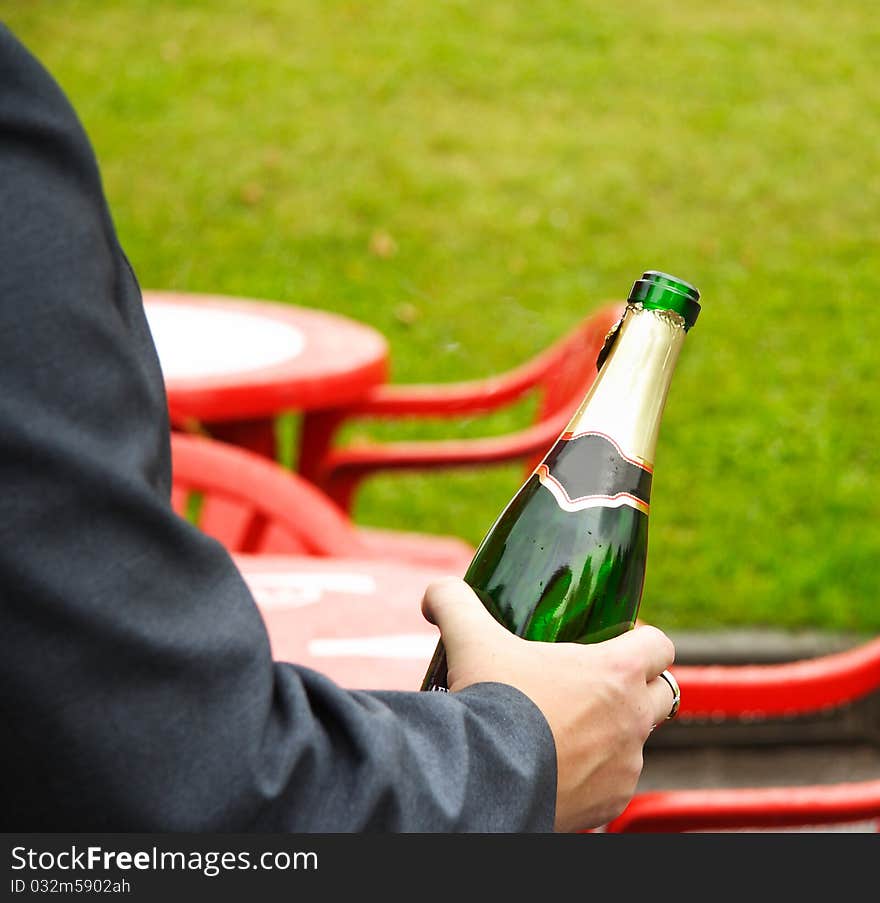 The image of champagne bottle in the men's hand