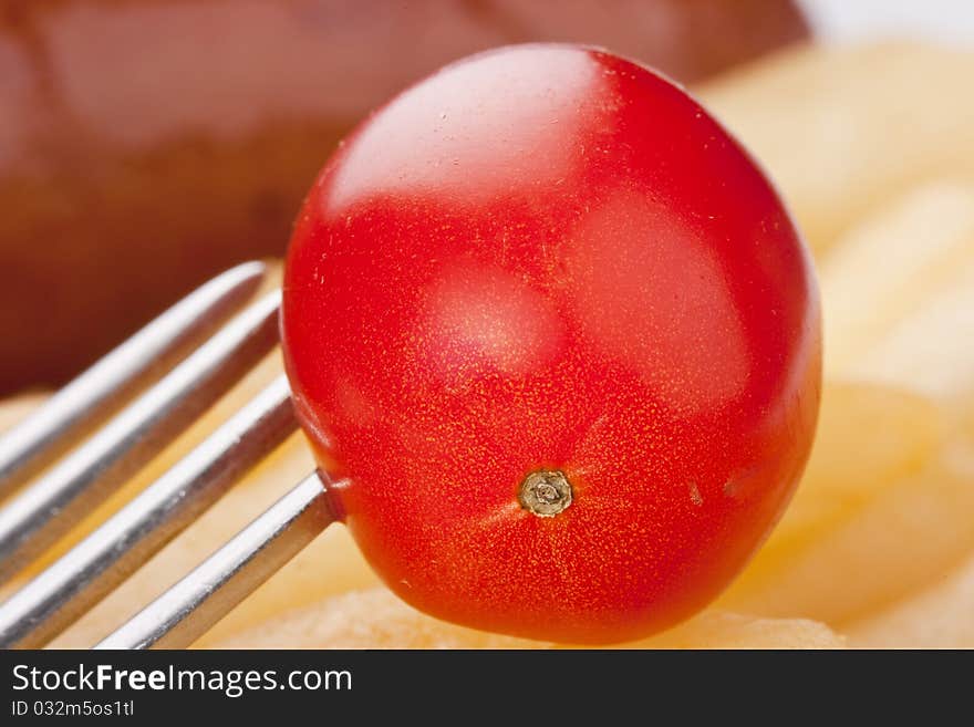 Ripe tomato in a plate with a fried potato.