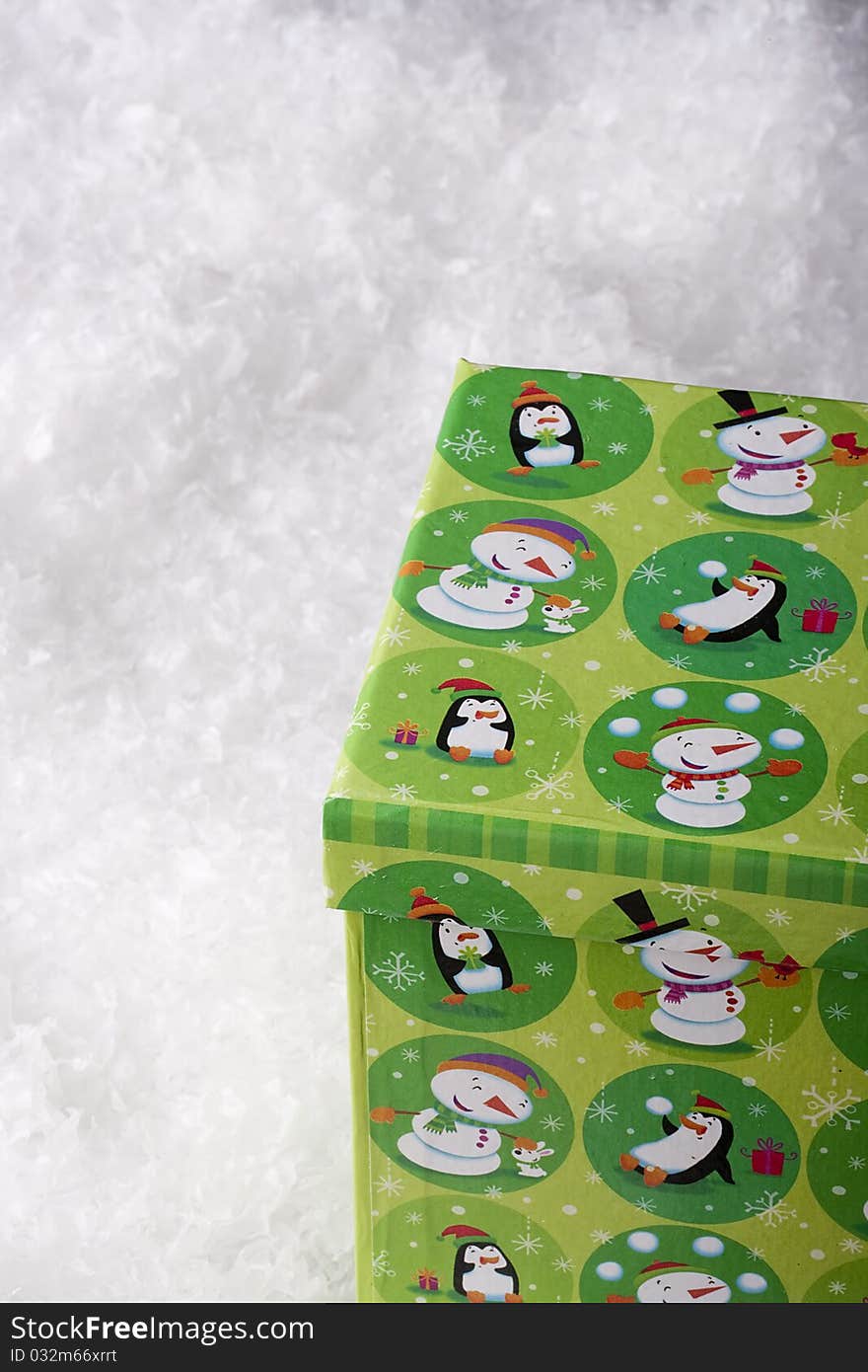 Green gift box for Christmas on a background of decorative snow.