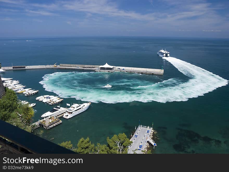 Harbour of Sorrento on the Amalficoast in the Mediterranean in South Italy, Europe. A taxi-boat is leaving the harbour in a hurry. See the slipstream