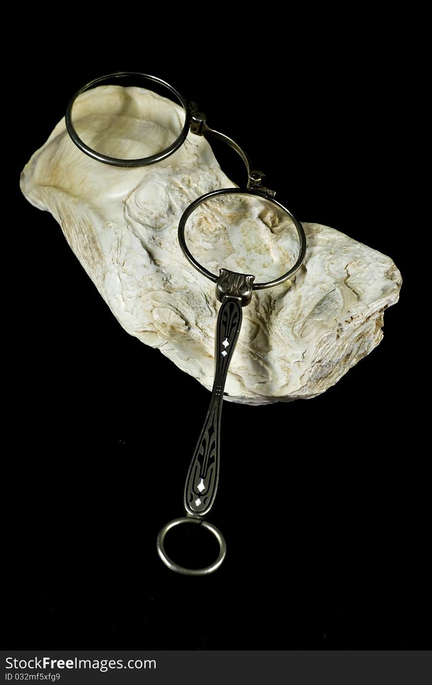 Old-fashioned glasses lying on white stone isolated on black. Old-fashioned glasses lying on white stone isolated on black.