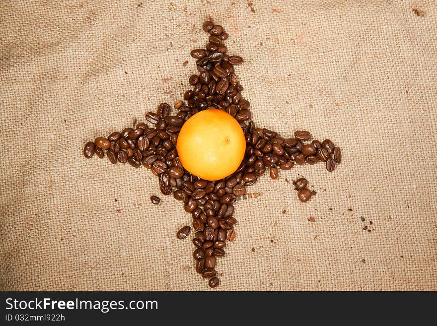 Star of fragrant fried coffee beans with the tangerine in the center. Star of fragrant fried coffee beans with the tangerine in the center