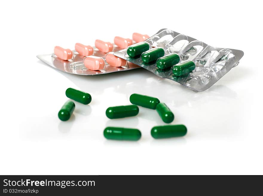 Green and pink pills isolated over white background. Green and pink pills isolated over white background.