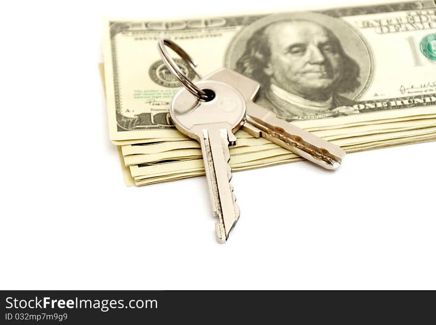 Keys and stack of dollars isolated on a white background