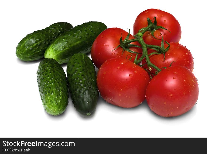 Ripe red tomatoes and cucumbers on a white background. Ripe red tomatoes and cucumbers on a white background