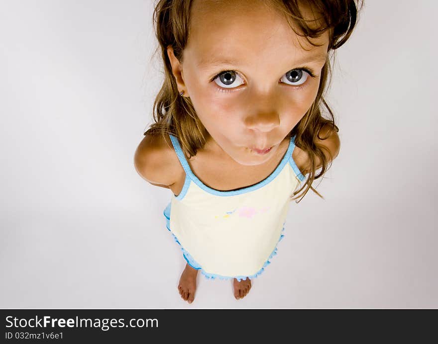 A sweet young girl. The child is on a white background. A sweet young girl. The child is on a white background