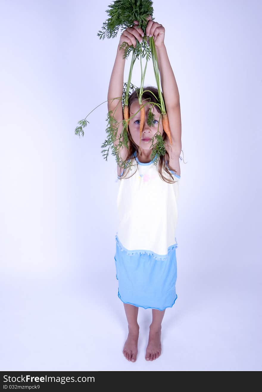 A little girl holding in her hand a beautiful carrots. A little girl holding in her hand a beautiful carrots