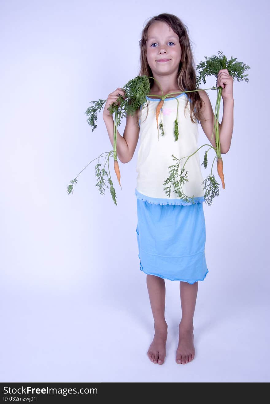 A little girl holding in her hand a beautiful carrots. A little girl holding in her hand a beautiful carrots