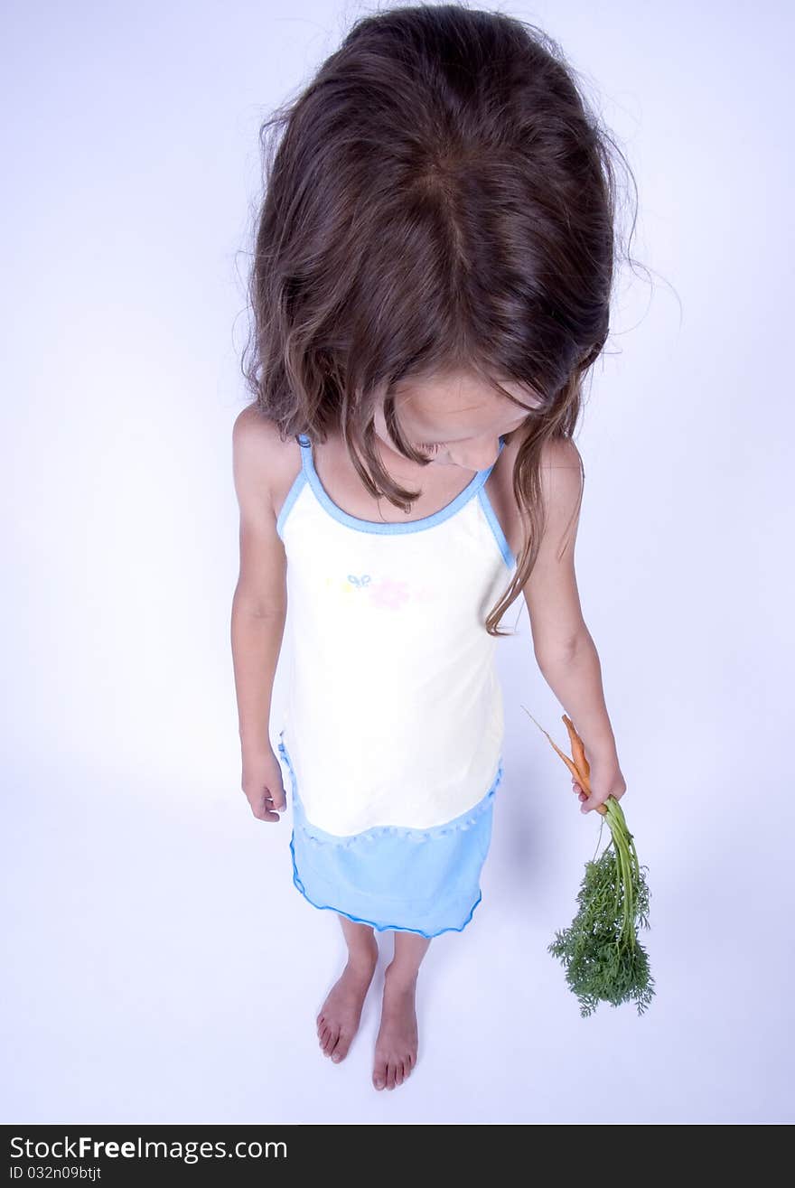 A little girl holding in her hand a beautiful carrots. A little girl holding in her hand a beautiful carrots