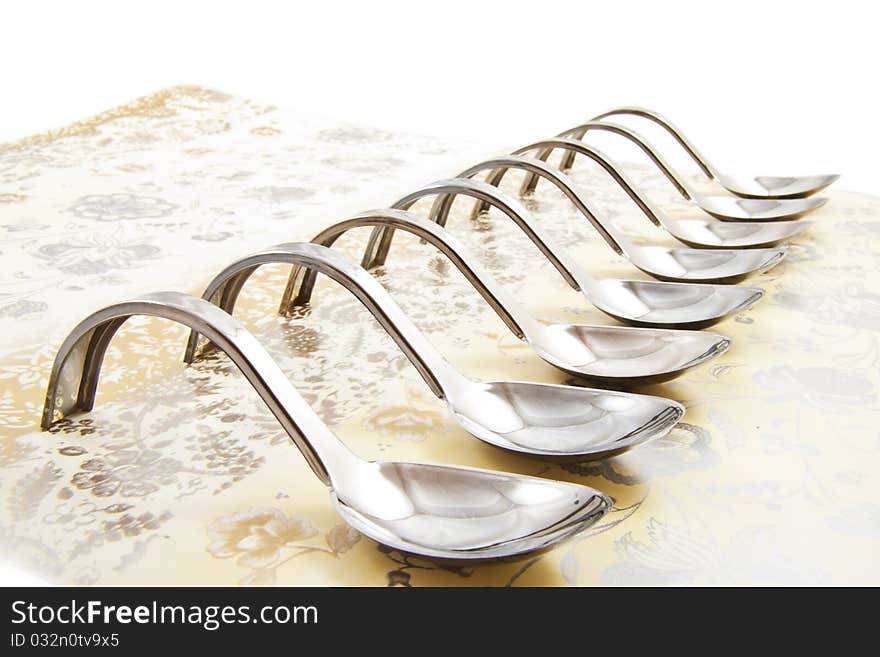 Empty amuse spoons in a row on a table cloth