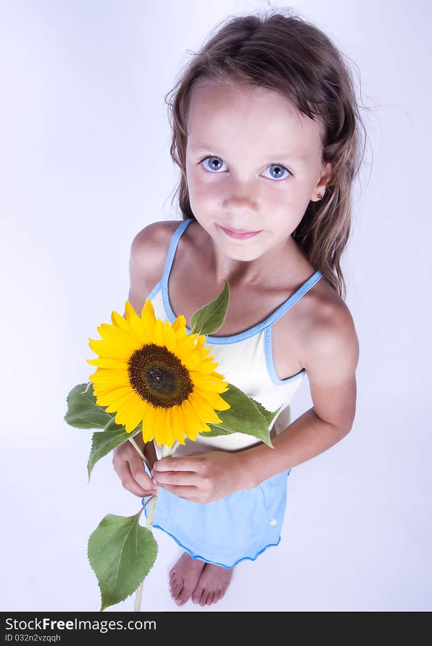 A little girl holding in her hand a beautiful sunflower