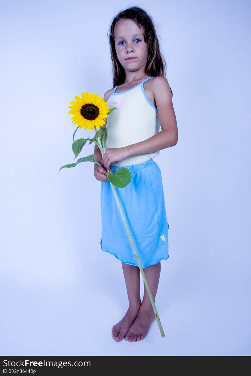 A little girl holding in her hand a beautiful sunflower