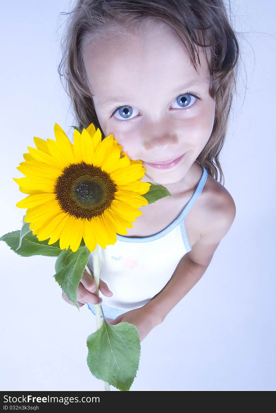 A little girl holding in her hand a beautiful sunflower