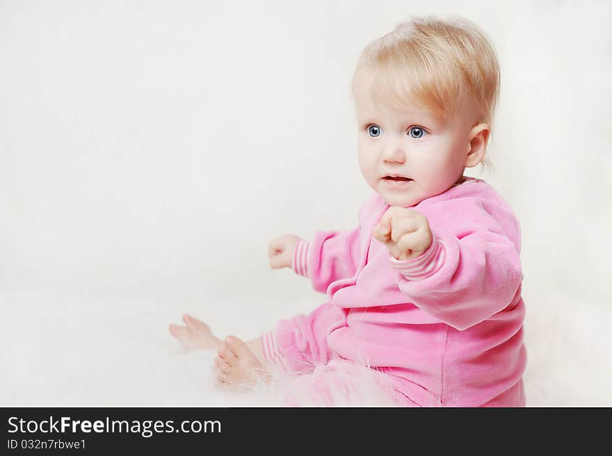 Portrait of a little baby wearing a pink snow suit on a soft blanket 
Image ID: 66482407