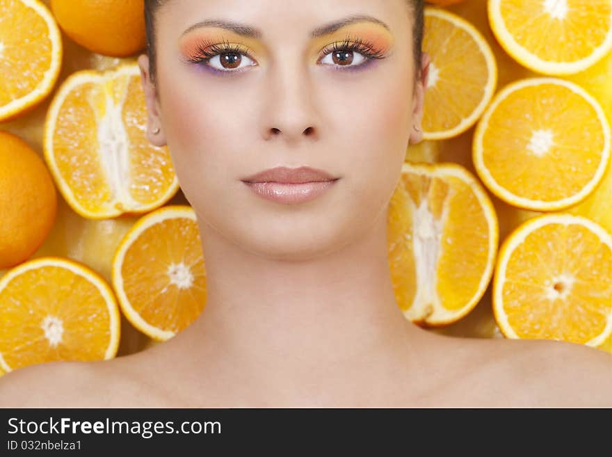 Young beautiful woman with oranges on background