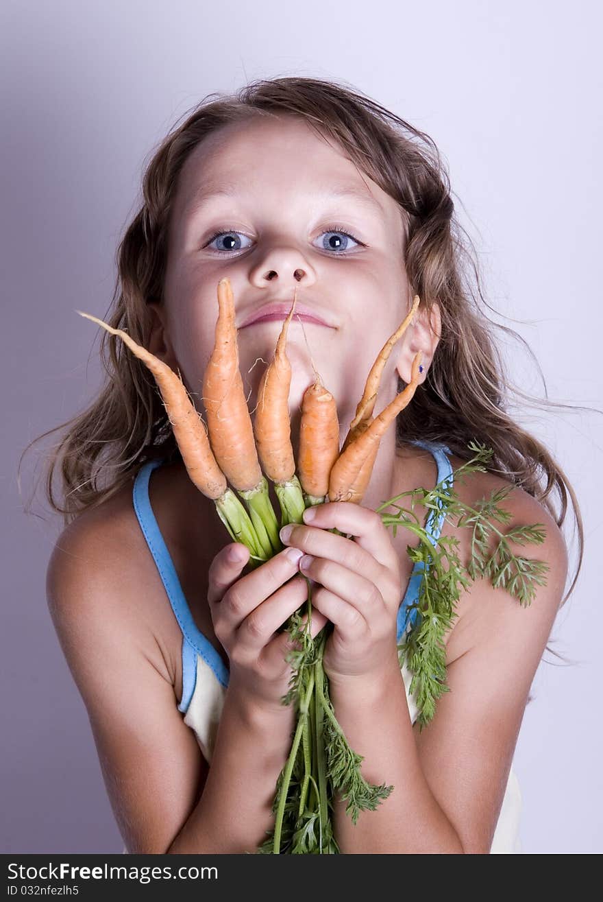 A little girl holding in her hand a beautiful carrots. A little girl holding in her hand a beautiful carrots