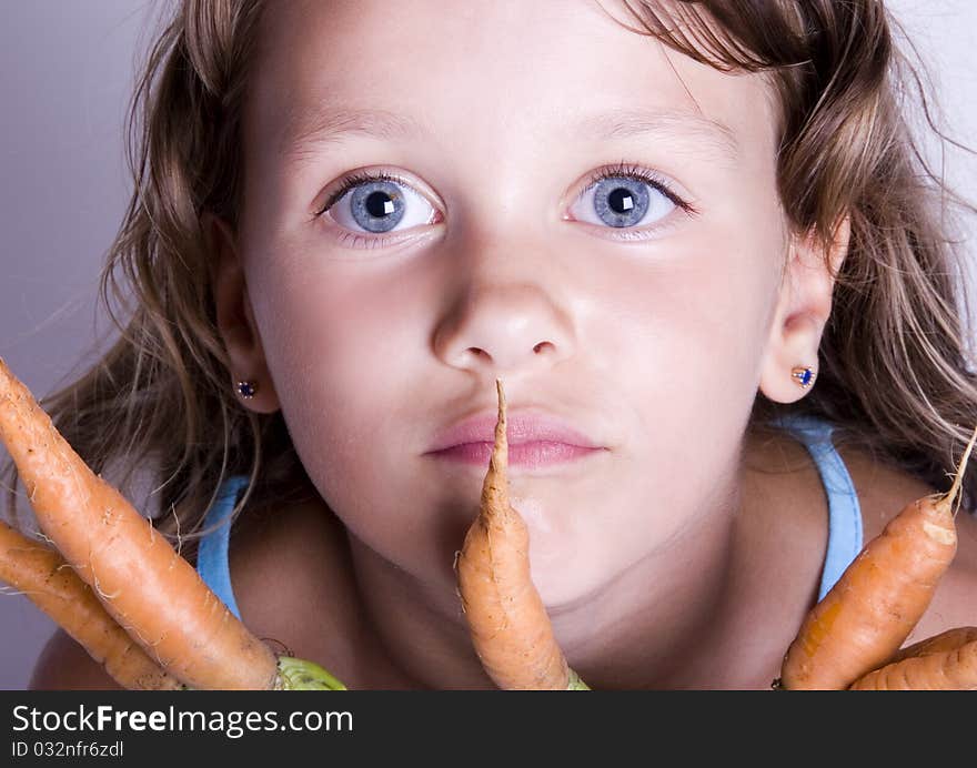 A little girl holding in her hand a beautiful carrots. A little girl holding in her hand a beautiful carrots