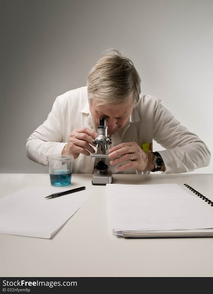 Senior scientist using a microscope. Senior scientist using a microscope