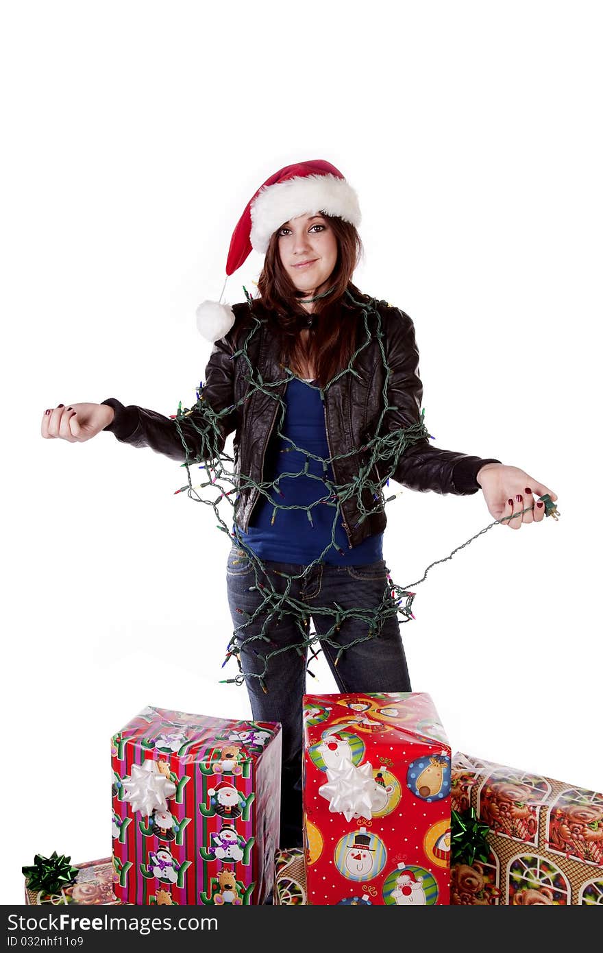 A woman all tied up in a bunch of Christmas lights by her presents with a frustrated expression on her face. A woman all tied up in a bunch of Christmas lights by her presents with a frustrated expression on her face.