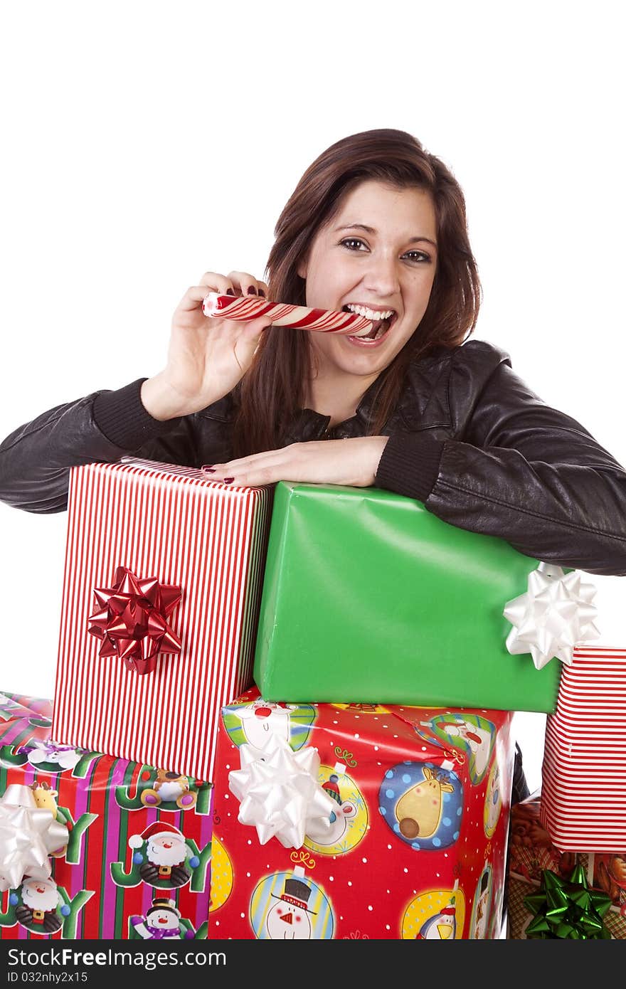 A woman leaning on her pile of Christmas presents while she eats her peppermint stick. A woman leaning on her pile of Christmas presents while she eats her peppermint stick.