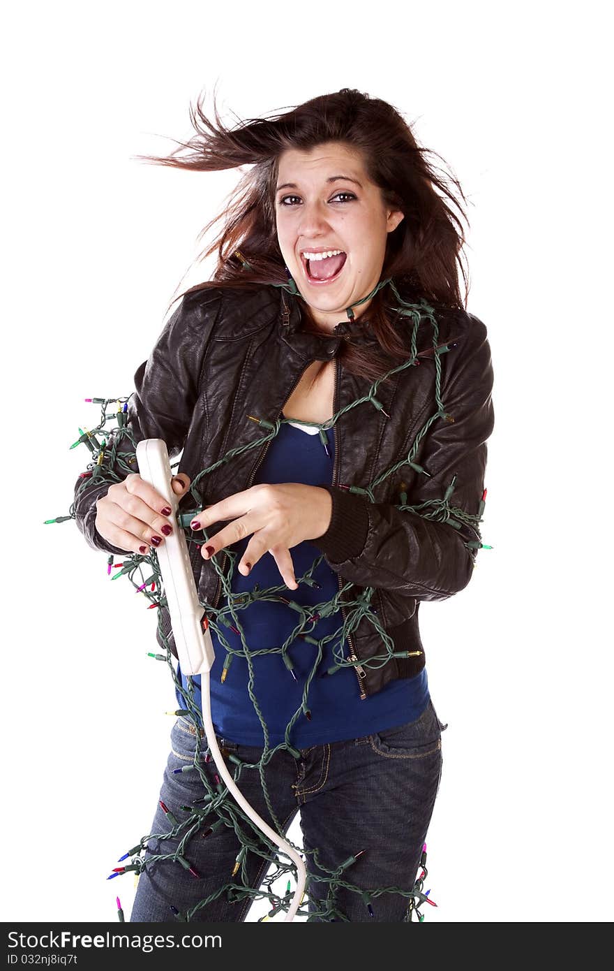 A woman all tied up in Christmas lights with a happy expression on her face and her hair standing up on end. A woman all tied up in Christmas lights with a happy expression on her face and her hair standing up on end.