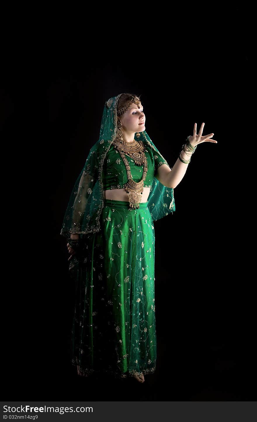 Young girl in green indian costume look at light